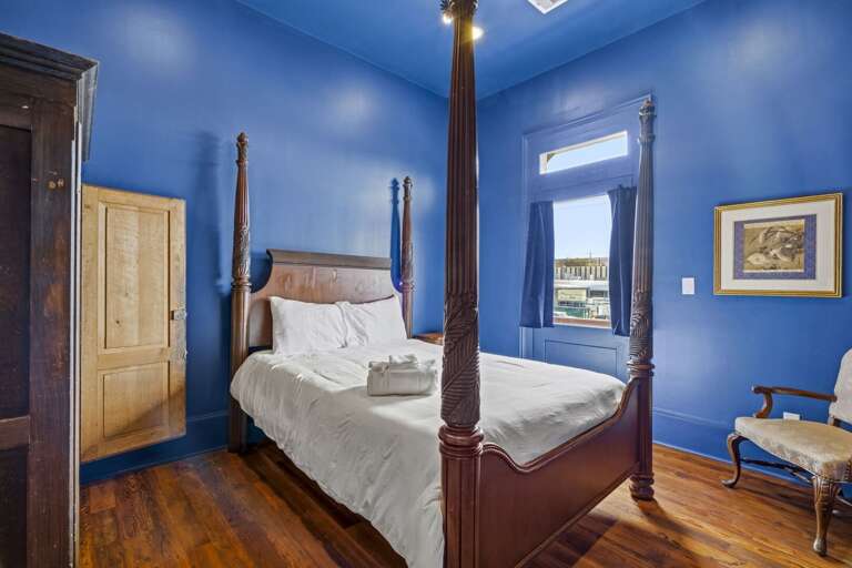Bold, stylish bedroom with rich blue walls and a classic four-poster bed for a dramatic, cozy retreat.