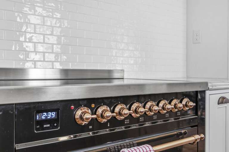 High-end range with sleek finishes and statement gold accents, perfect for cooking in style.