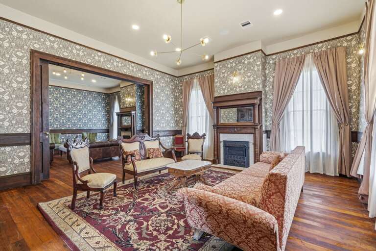 Sophisticated parlor with beautiful furnishings, a classic fireplace, and vintage elegance perfect for relaxing or entertaining.