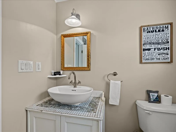 A clean and charming bathroom with a stylish vanity and thoughtful touches for a comfortable stay.