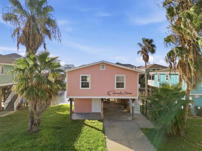 A charming exterior surrounded by palms welcomes you to your home away from home.