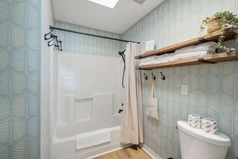 A cheerful coastal-inspired bathroom with a tub and shower offers extra convenience for your group.