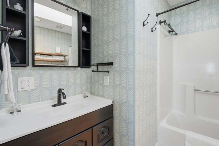 Fresh finishes and thoughtful touches give the second bathroom a relaxed beach-house feel.