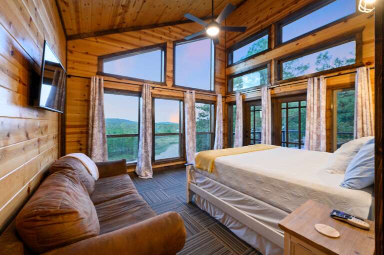 Master bedroom with king bed, couch, smart TV, balcony and mountain views.