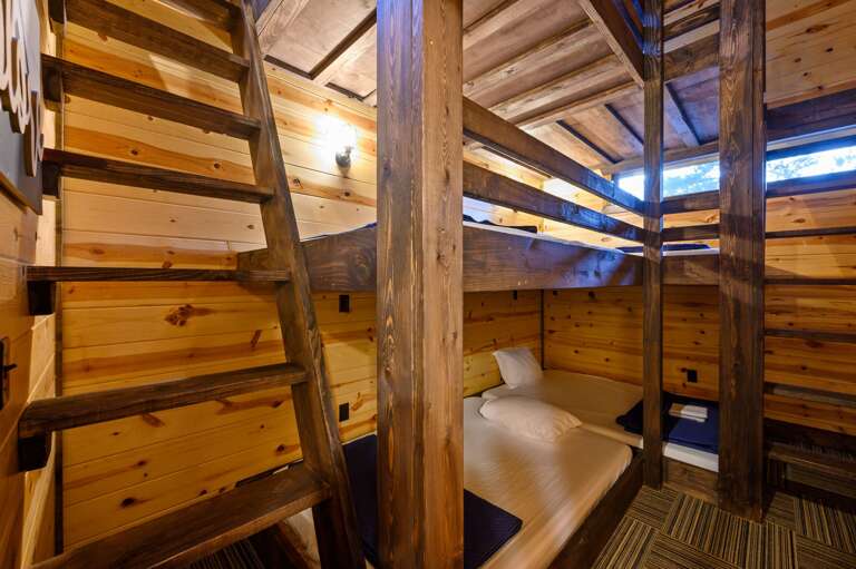 Upstairs bunk bedroom with triple full bed bunks, a full bed loft, and TV.
