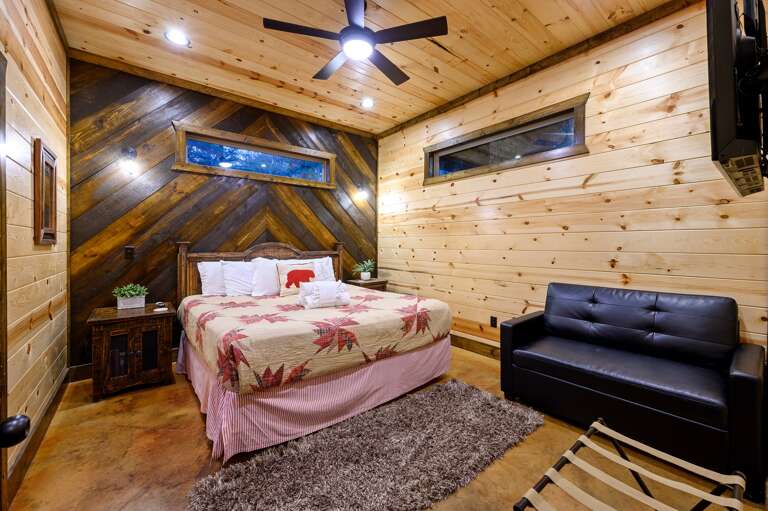 Downstairs bedroom with king bed and futon bed, TV.