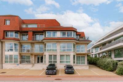 Multi-level Vacation Rental Facing A Paved Parking Lot, Balconies Beneath Blue Skies