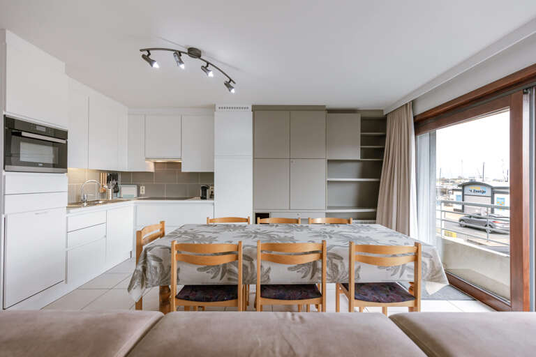 Interior Space Showing Kitchen, Dining Area With Wood Table And Balcony View