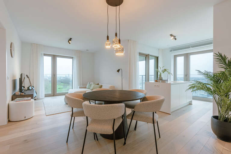 Minimalistic White-walled Residence With Round Dining Table, Glass Doors, And Pendant Lights