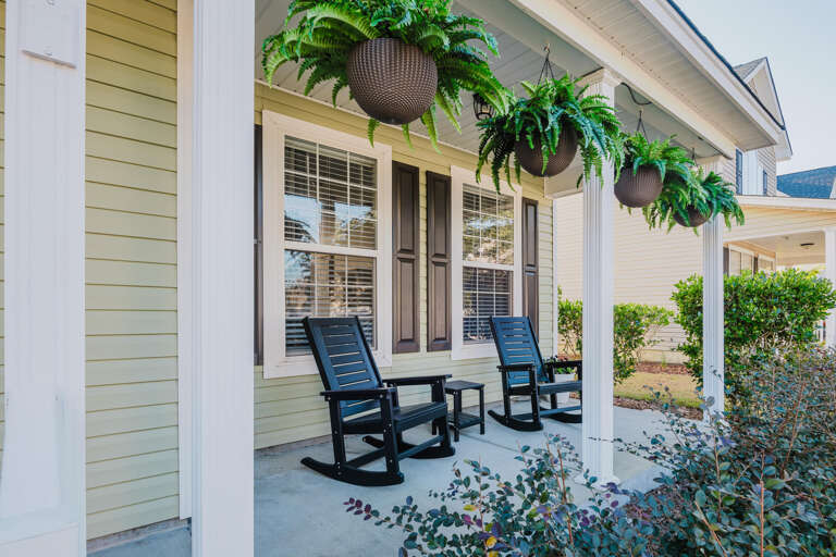 Porch With Planters, Pillars, And Rocking Chairs