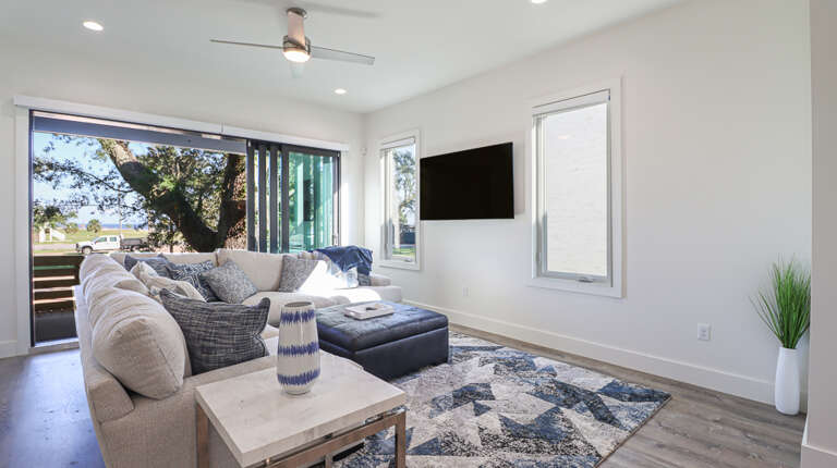 Luxurious and Modern Beach House Living Room with Doors Leading Out Toward the Beach
