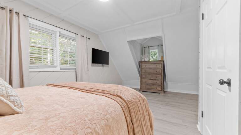 Upstairs bedroom w/ dresser and smart TV