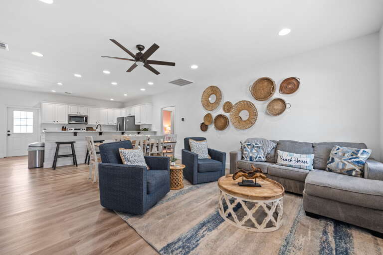 This spacious living room is the perfect place to entertain guests or simply relax after a long day. The room boasts high ceilings and large windows that allow for plenty of natural light to flood in, creating a bright and inviting atmosphere.