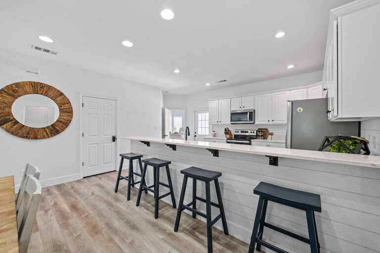 The large center island provides ample space for meal prep and casual dining, while the open floor plan allows for easy entertaining.