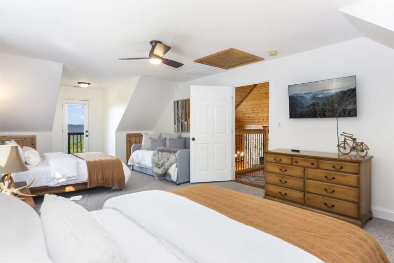 Bedroom w/ 2 queen beds, twin, dresser, and TV