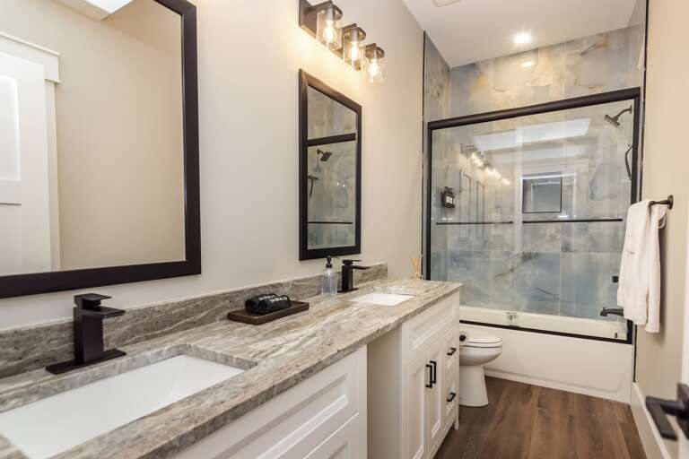 Full bathroom w/ dual sinks and tile shower