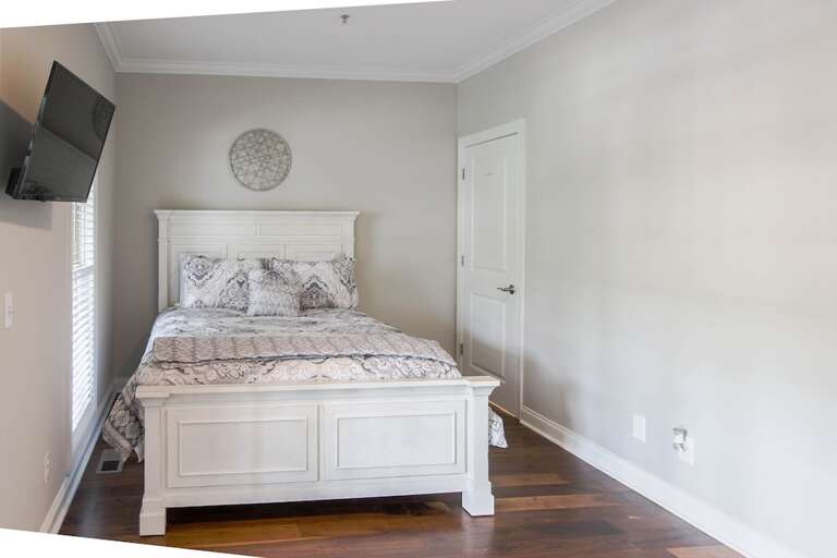 Bedroom 2 with queen bed and mounted tv