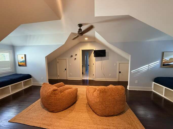 Upstairs bedroom  w/ 2 twin beds, lounge area, smart TV, and 2 desks 