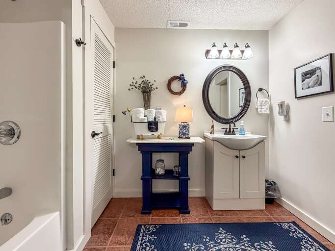 Vanity area and tub/shower combo.