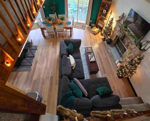 Interior Living Space With Sectional Sofa, Wooden Floors, Staircase, And Christmas Decorations