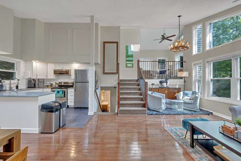 Spacious, Sunlit Interior View Of A Multi-level Living Space With Kitchen, Dining Area, And Lounge