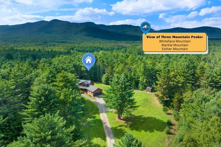 Cabin Nestled In Lush, Leafy Landscape With Mountain Backdrop