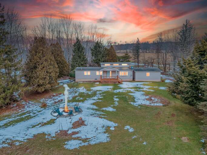 Sunset Shades Over Snowy Vacation Rental Nestled Between Bare Trees