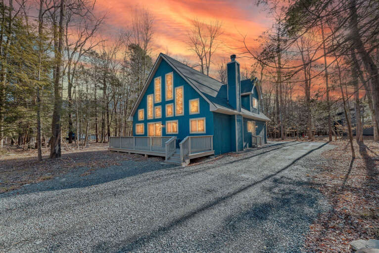 Blue Building Beneath Blazing Sunset, Surrounded By Bare Branches