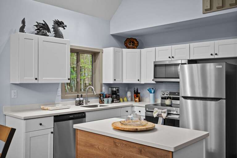 Sleek Kitchen With Stainless Steel Appliances And White Cabinets