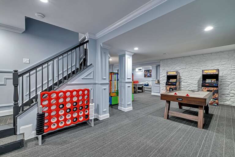 Basement Game Room With Stairs, Arcade Machines, And Connect Four