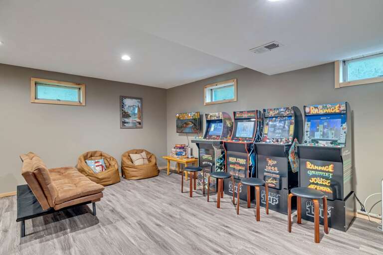 Basement Gaming Area With Arcade Machines And Plush Seating