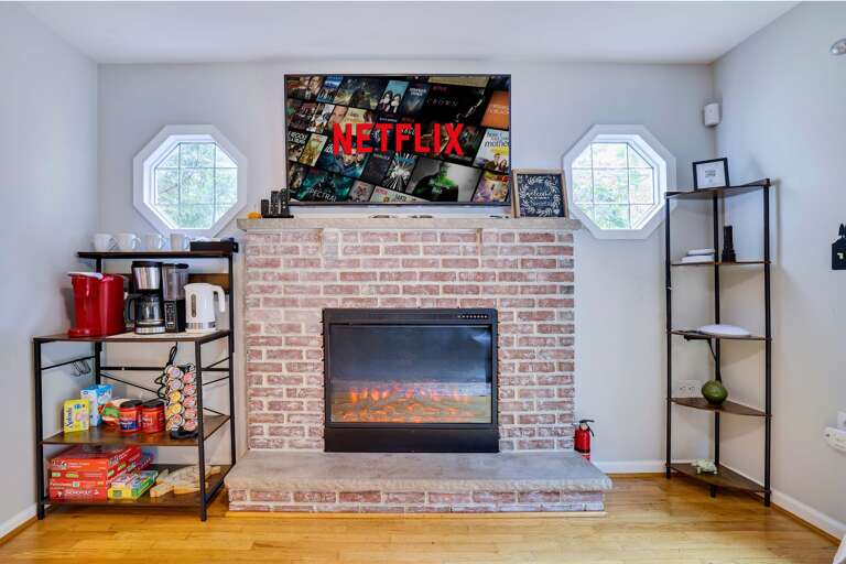 Living Area With Brick Fireplace And Mounted TV Streaming Netflix