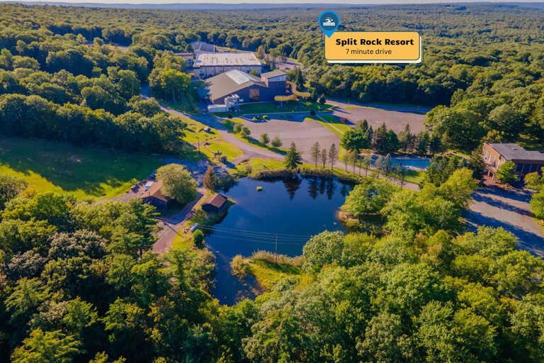 Lush Landscape With Lake And Trees Surrounding Buildings