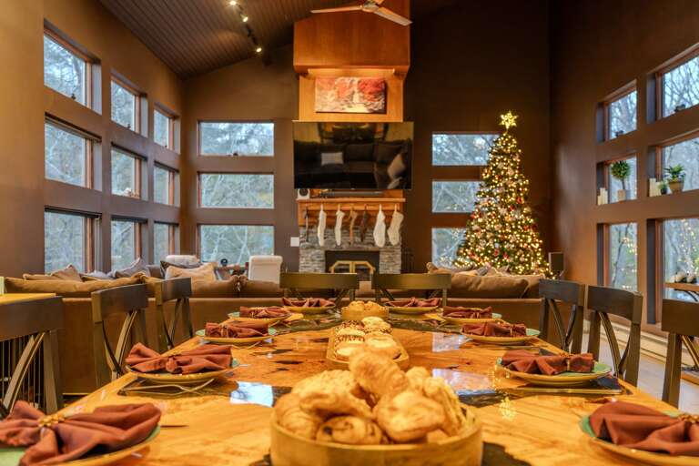 Festive Feast Setup In Spacious Vacation Rental With A Decorated Christmas Tree