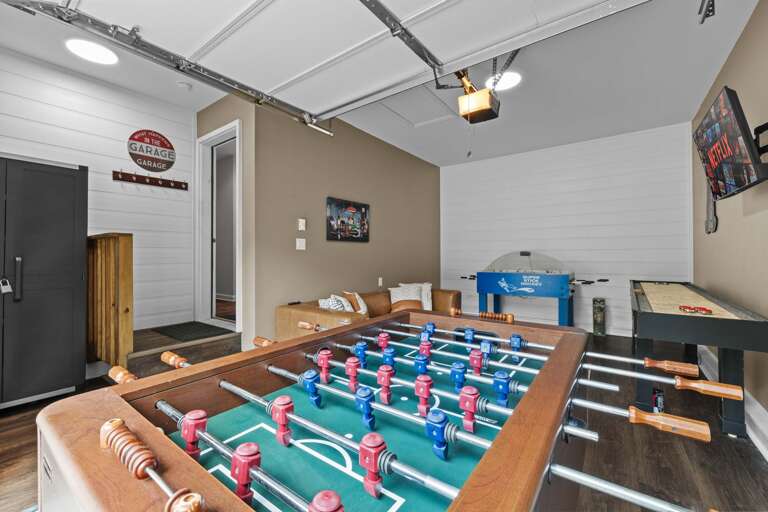 Game Room Featuring Foosball, Arcade Machine, And Exposed Beam Ceiling