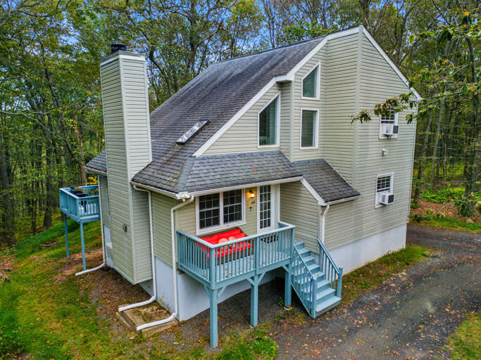Triangular-roofed House, Teal Trim, Tree-lined Surroundings