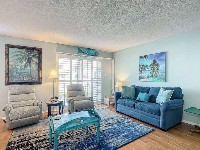 Relax in a cozy living room with colorful beach-inspired decor and comfortable seating.