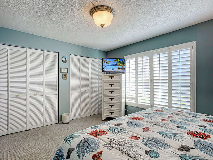 Sleep soundly in this airy bedroom with beach-inspired decor, ample storage, and a sunny window view.