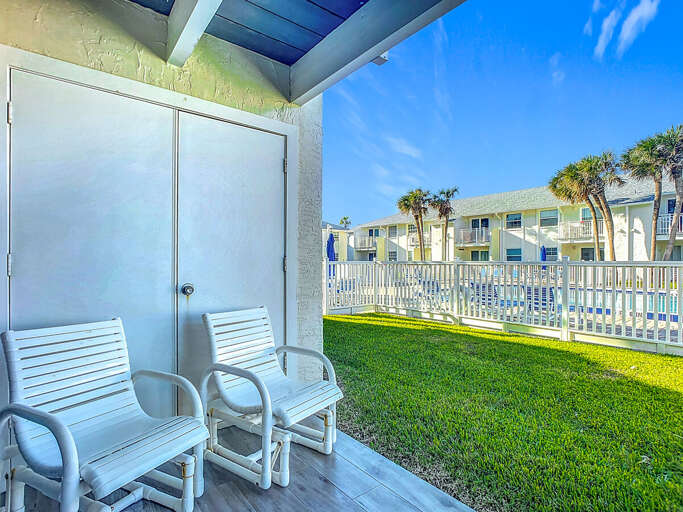 Unwind on the cozy patio with comfortable seating and a peaceful view of the pool and garden.
