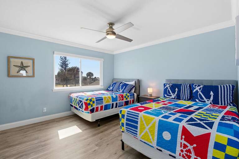 Bright coastal bedroom with two comfortable beds and nautical décor, perfect for families or