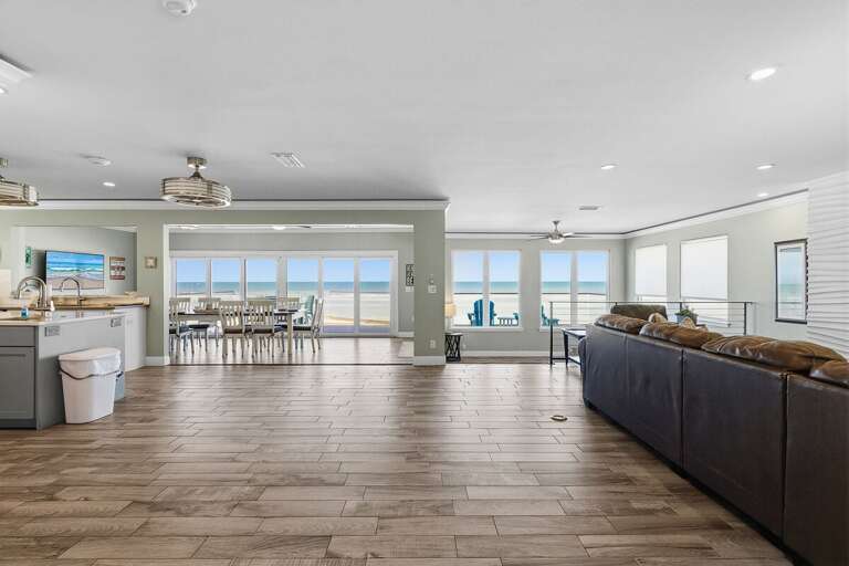 Expansive open living, dining, and kitchen space with panoramic ocean views and direct balcony