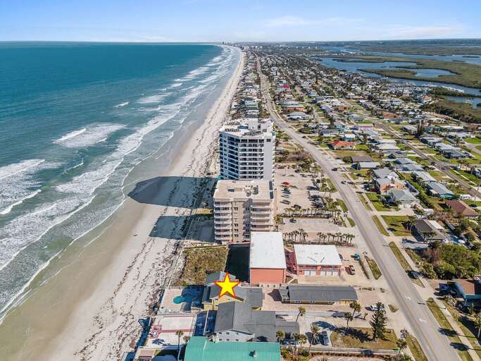 Stunning aerial view of this beach stay showcasing direct oceanfront access, nearby attractions, and coastal charm. Ideally located for a relaxing seaside getaway with sweeping shoreline views.