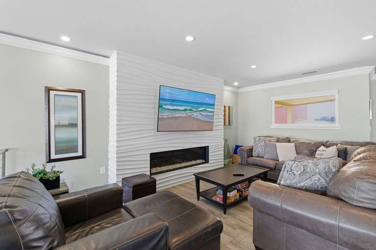 Unwind in this inviting living room featuring plush seating and a sleek fireplace. Perfect for your