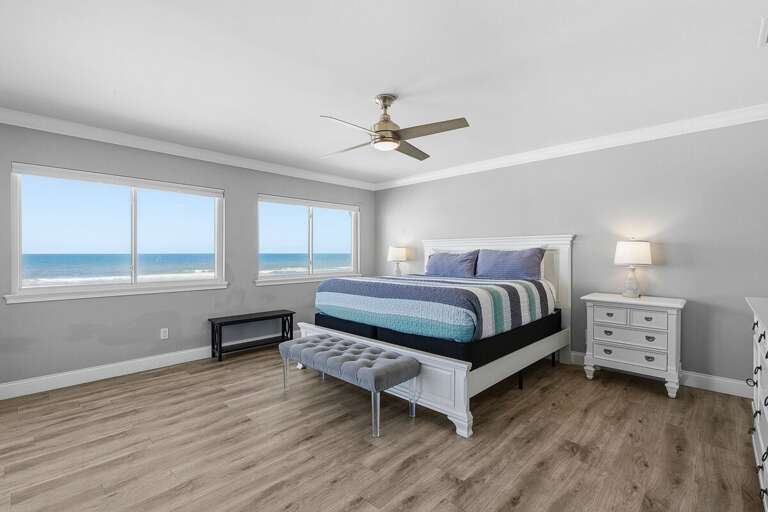 Unwind in this spacious king bedroom featuring calming coastal décor and stunning ocean views.