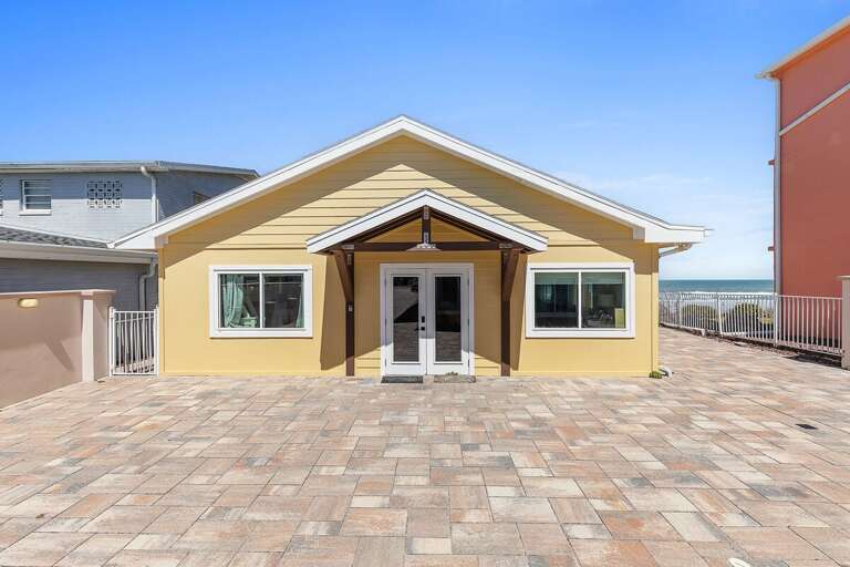 Bright coastal beach stay cottage with inviting entry, spacious patio, and ocean views nearby. Enjoy a relaxing seaside escape with easy beach access, perfect for a laid-back vacation getaway.