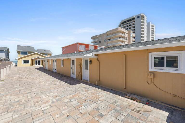 Comfortable beach stay property featuring multiple units, a large paved courtyard, and close