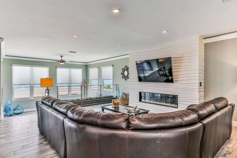 Enjoy stunning beach views from this chic oceanview lounge featuring a sleek fireplace, spacious leather seating, and natural light—perfect for unwinding after a sun-soaked beach stay.