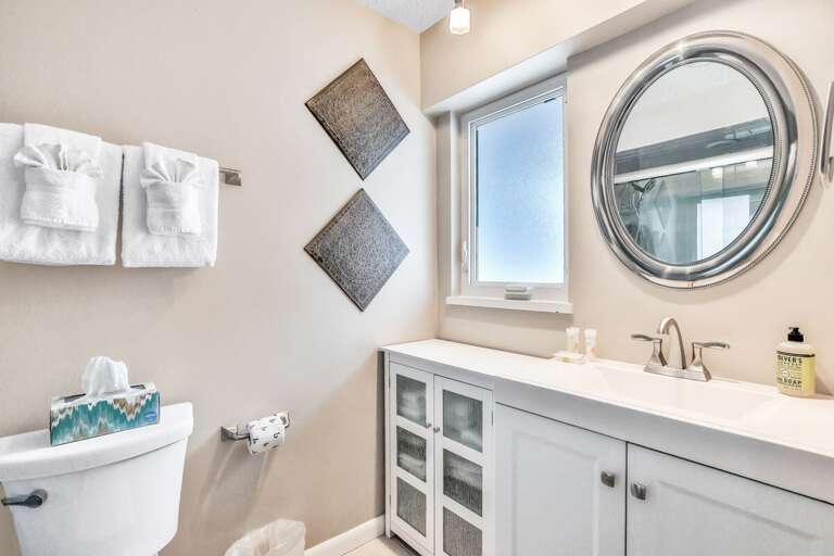 A fresh, beach-inspired bathroom featuring soft neutrals, modern fixtures, and plush towels—perfect for unwinding after a sun-soaked beach stay. Clean, bright, and relaxing.