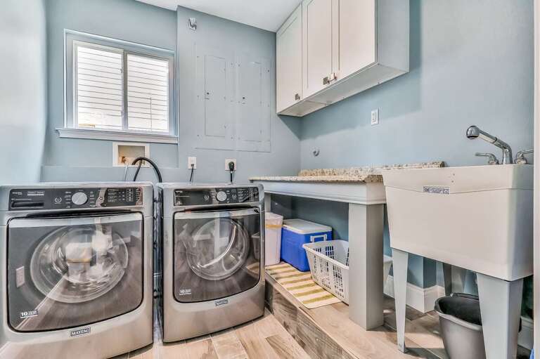 This fully equipped laundry room with modern appliances and a utility sink makes refreshing beachwear easy during your stay—perfect for long seaside vacations.