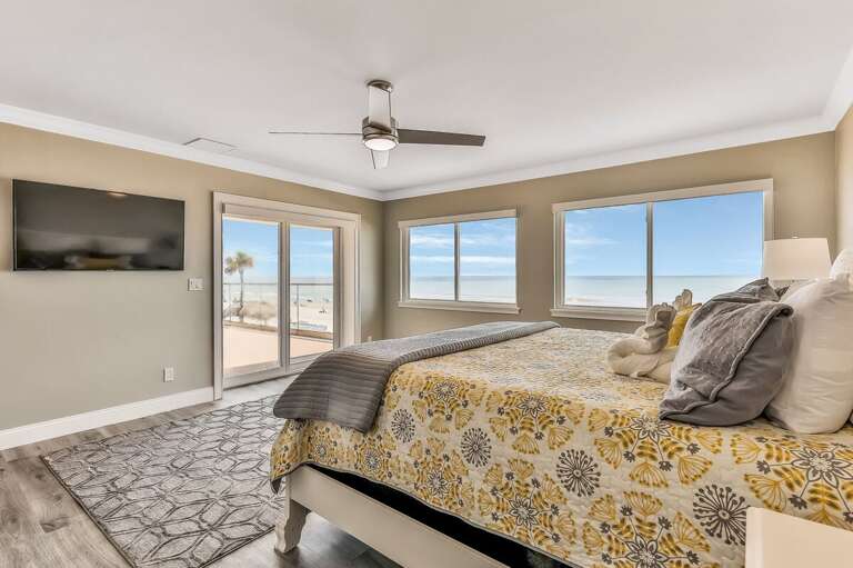 Wake up to stunning ocean views in this bright beachside primary bedroom. Enjoy a cozy king bed, private balcony access, and plenty of natural light—perfect for a relaxing beach stay.